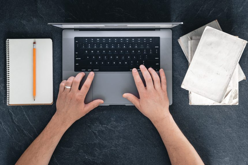 a man is using a laptop books and a notebook top 2025 03 16 23 48 44 utc